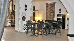 A dining area with a table and chairs, a lamp, and a decorative vase. - Dolce Vita Casa Vacanze (Carini)