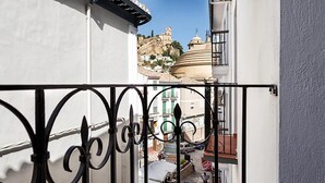 Una calle estrecha con un edificio blanco y una estructura en forma de cúpula al fondo.