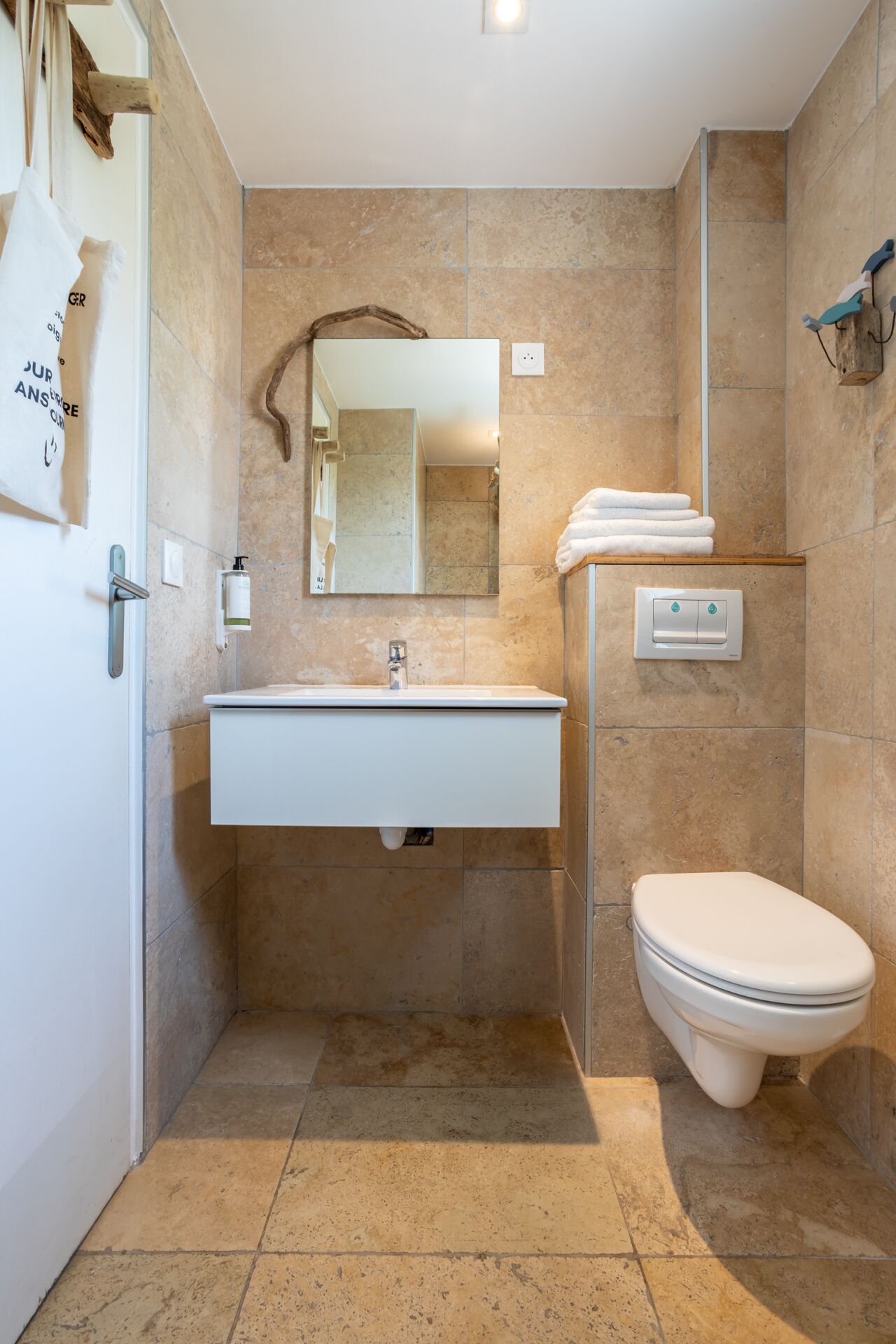 A bathroom with a white sink, mirror, and toilet.