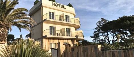 A hotel with a two-story structure, balconies, and a wooden fence in the foreground.
