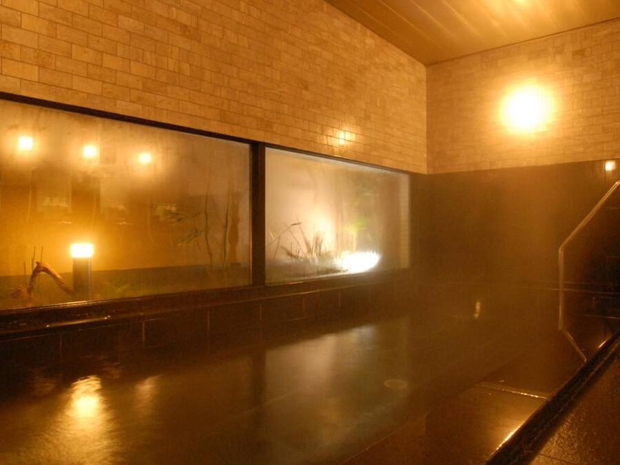 A corridor with a brick wall and a glass window.