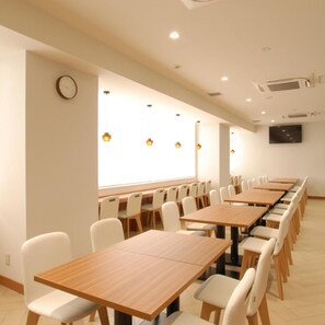 A conference room with long tables and chairs, a clock on the wall, and a television mounted on the wall. - Ab Hotel Fuji (Fuji)