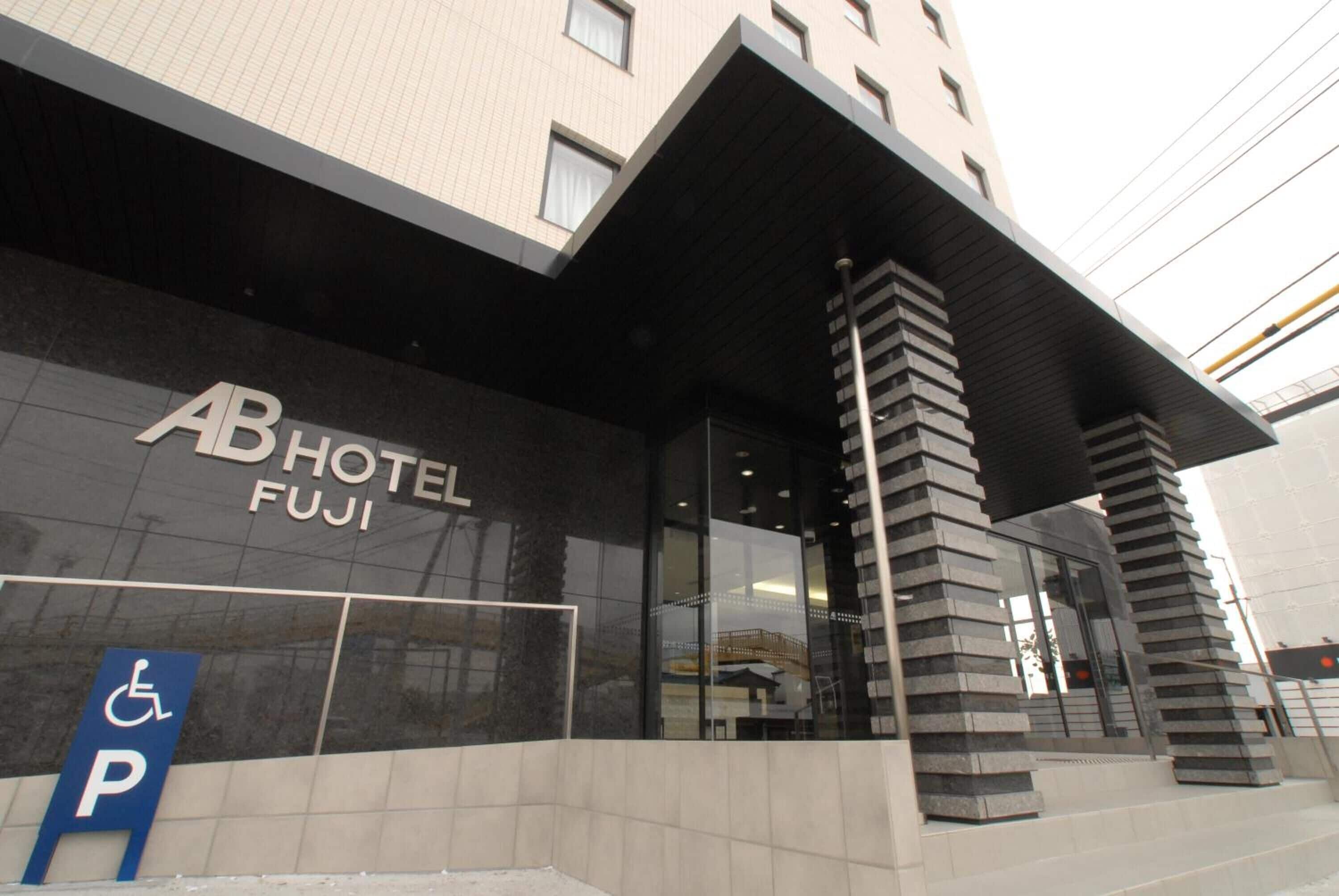 A hotel entrance with a sign reading 'AB HOTEL FUJI' and a disabled parking sign.