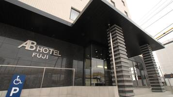 A hotel entrance with a sign reading 'AB HOTEL FUJI' and a disabled parking sign.