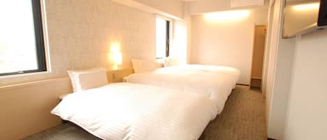 A hotel room with two beds, a window, a wall-mounted air conditioner, and a carpeted floor.