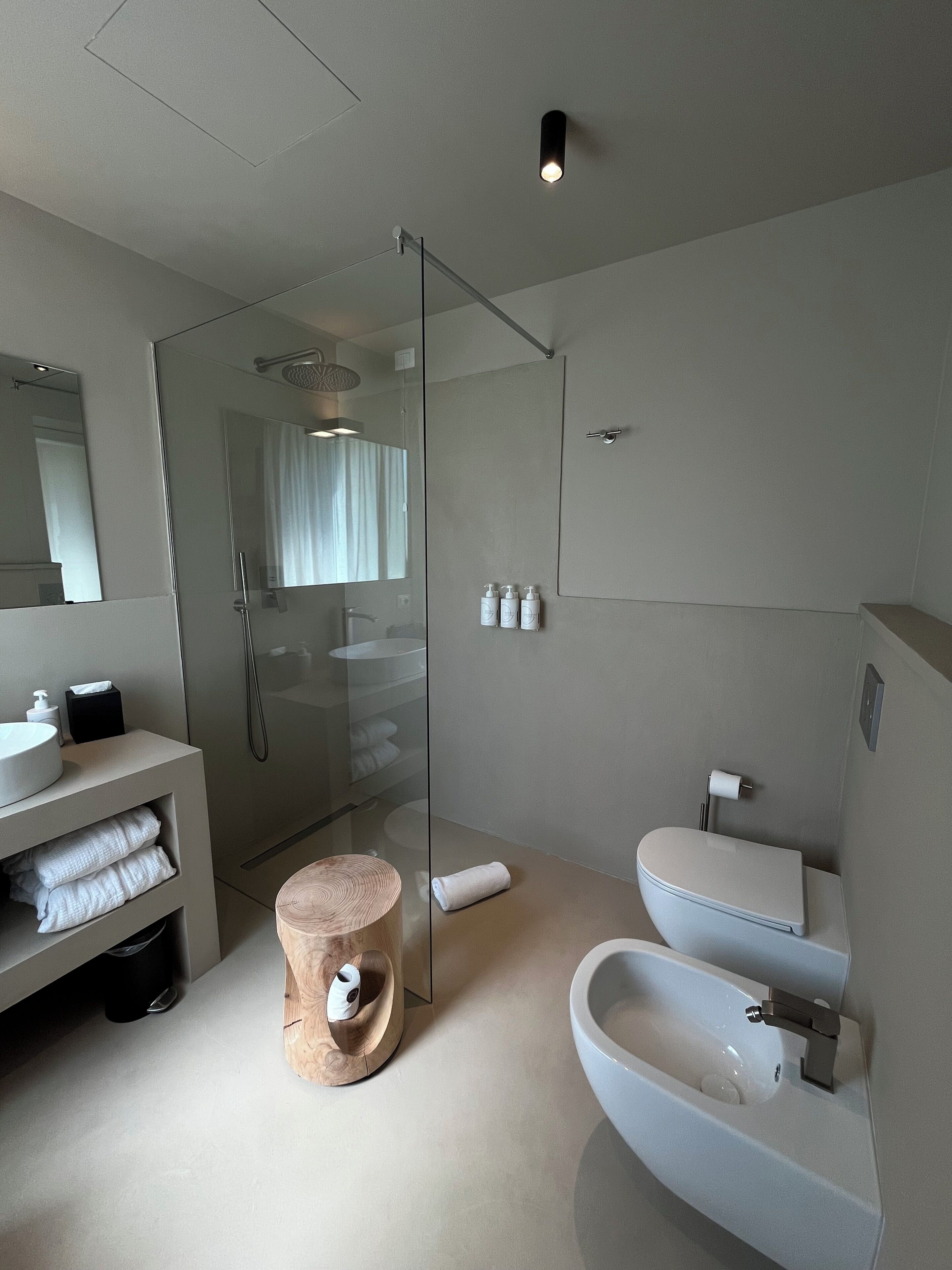 Un baño moderno con ducha de vidrio, lavamanos blanco y una bañera grande.
