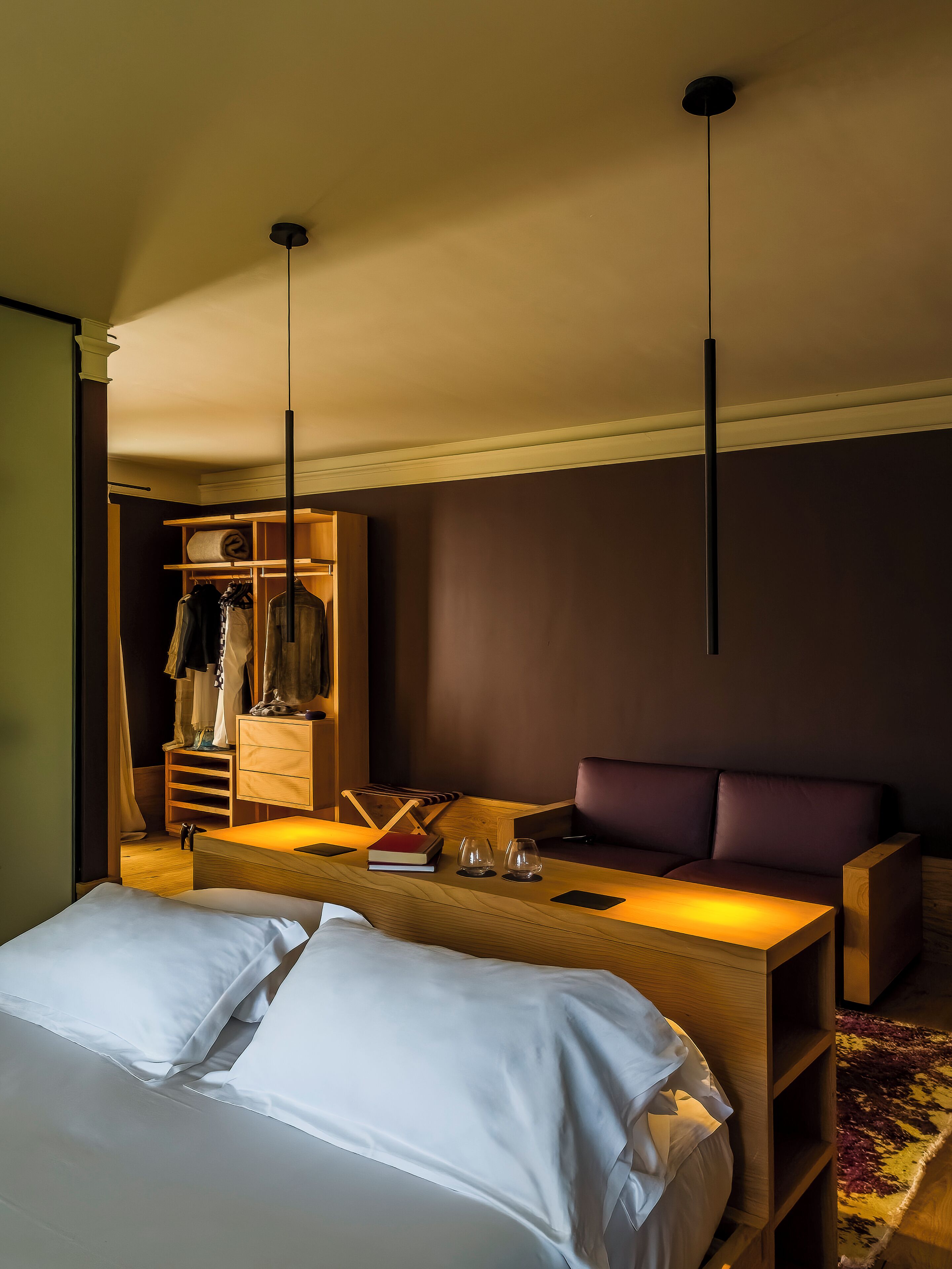 Ein Hotelzimmer mit einem Bett, einer Sitzecke mit einer Couch, einem Holzschrank und einem Kleiderschrank.
