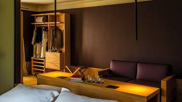 Ein Hotelzimmer mit einem Bett, einer Sitzecke mit einer Couch, einem Holzschrank und einem Kleiderschrank.