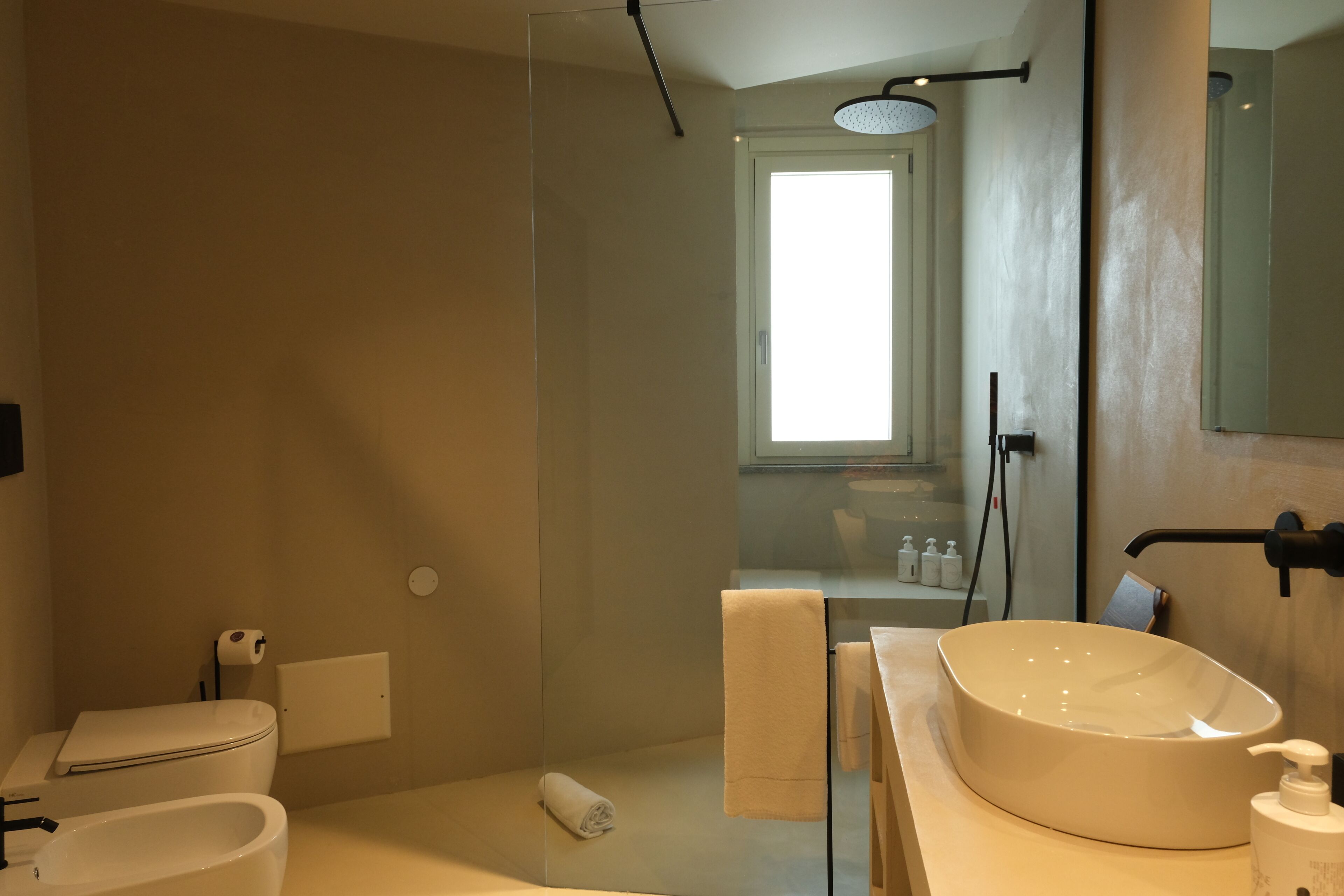 A modern bathroom with a bathtub, a toilet, a sink, and a shower.