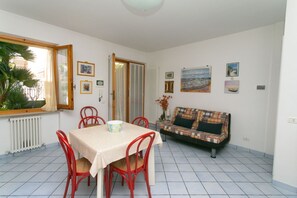 A dining area with a table, chairs, and a sofa.