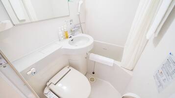 Ein kleines, weißes Badezimmer mit Toilette, Waschbecken und Dusche.