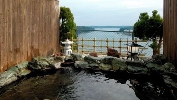A koi pond with a wooden fence, a stone pathway, and a lantern. - Ikadaso Sanjo (Shima)