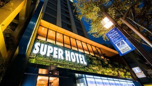 A hotel with a prominent 'Super Hotel' sign, a modern facade, and a signboard with Japanese text. - Super Hotel Tokyo Kinshicho Ekimae (Tokyo)