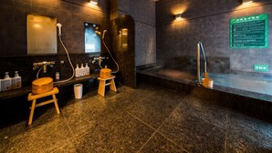 A modern spa with dark tiled walls, wooden accents, and a steam shower area. - Super Hotel Tokyo Kinshicho Ekimae (Tokyo)