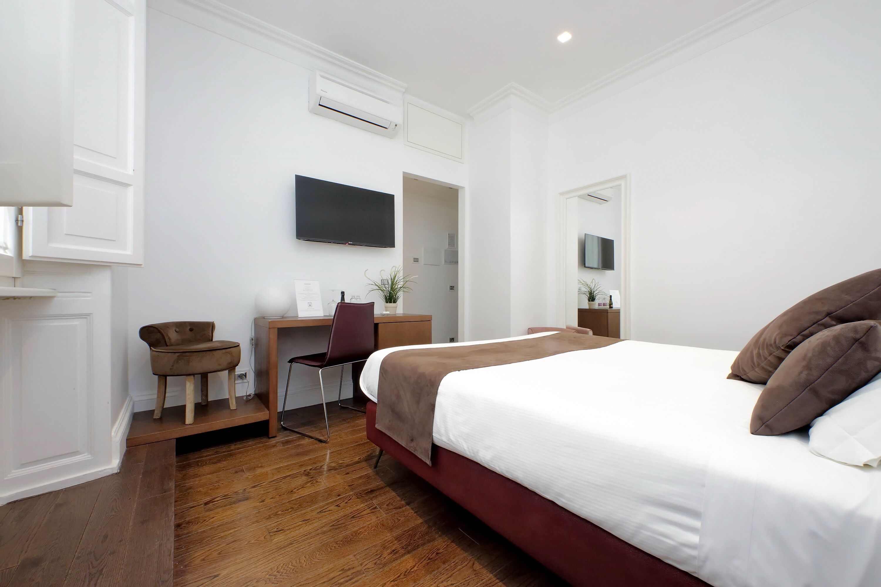 Una habitación de hotel con una cama grande, un escritorio, una silla y un televisor.