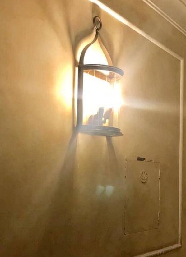 Una lámpara de pared con un diseño curvo y una caja eléctrica visible en la parte inferior.