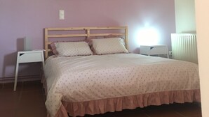 Un dormitorio con cama, mesita de noche, un cuadro en la pared y un radiador.