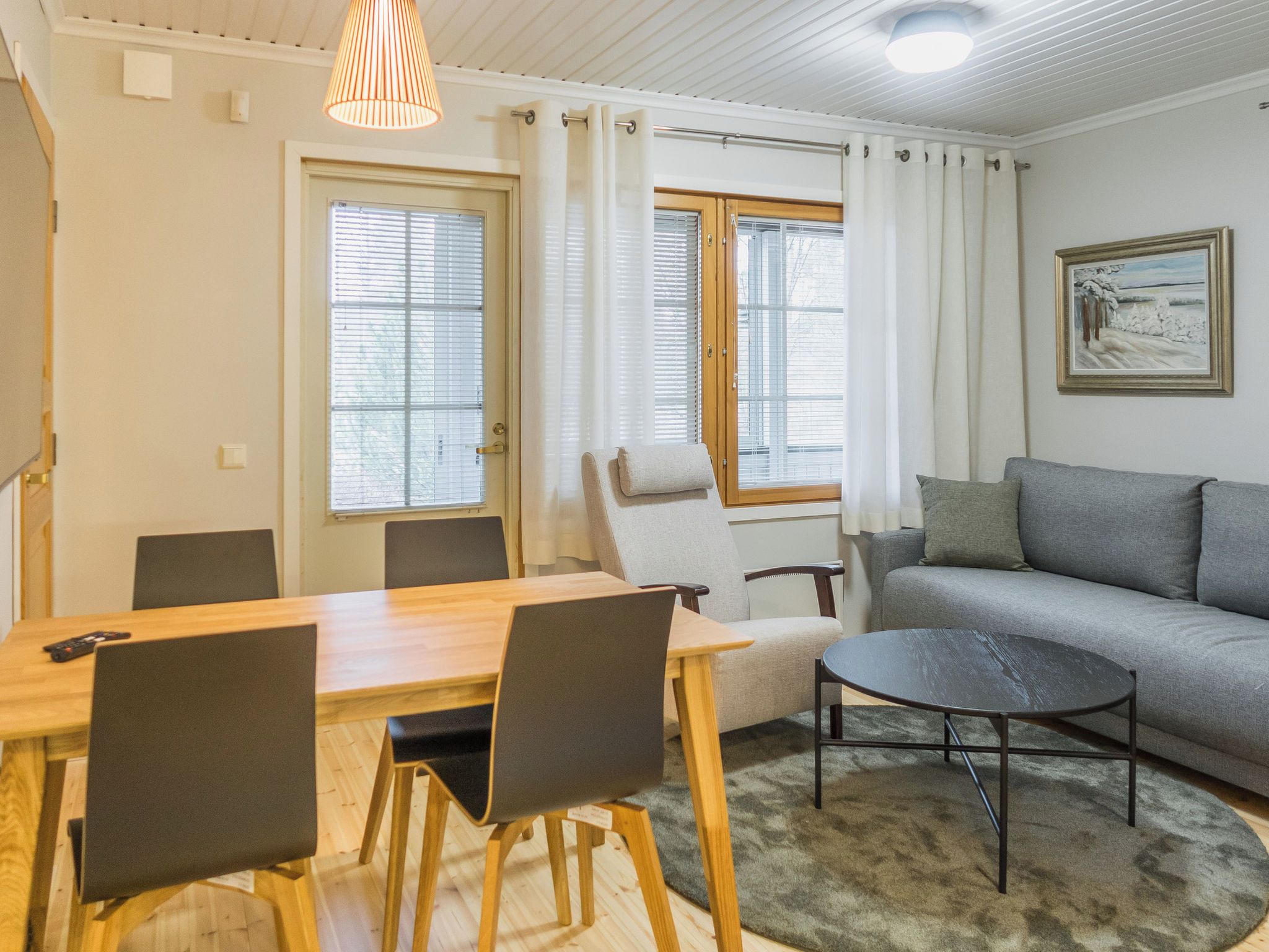 Olohuone, jossa on sohva, ruokapöytä tuoleineen ja sohvapöytä.