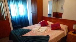 A hotel room with a bed, a nightstand, a lamp, and a mirror. - Hospedaria D. Damélio (Lisbon)