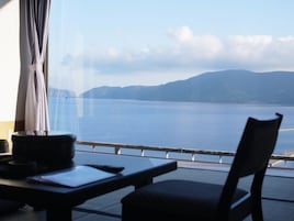 Habitación con vista a una gran masa de agua y montañas distantes.
