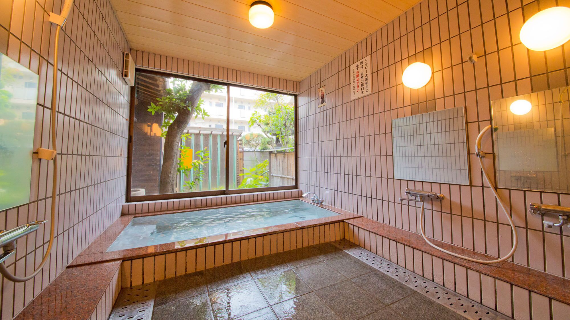 A traditional Japanese-style bath with a sliding door, a small window, and a tiled wall.