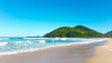 Perto da praia, areia branca, prática de windsurfe