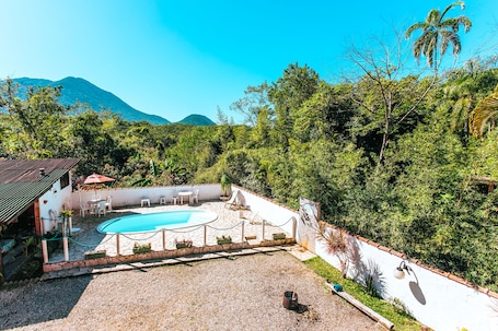 Una piscina al aire libre, sombrillas, sillones reclinables de piscina