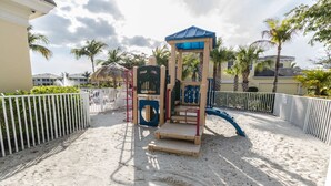 Ein Spielplatz mit Klettergerüst, Rutschen und einem eingezäunten Bereich.