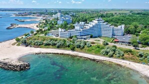 A coastal hotel with multiple buildings, a beach, and clear blue waters. - HOTEL OPAL Cap Aurora (Jupiter)