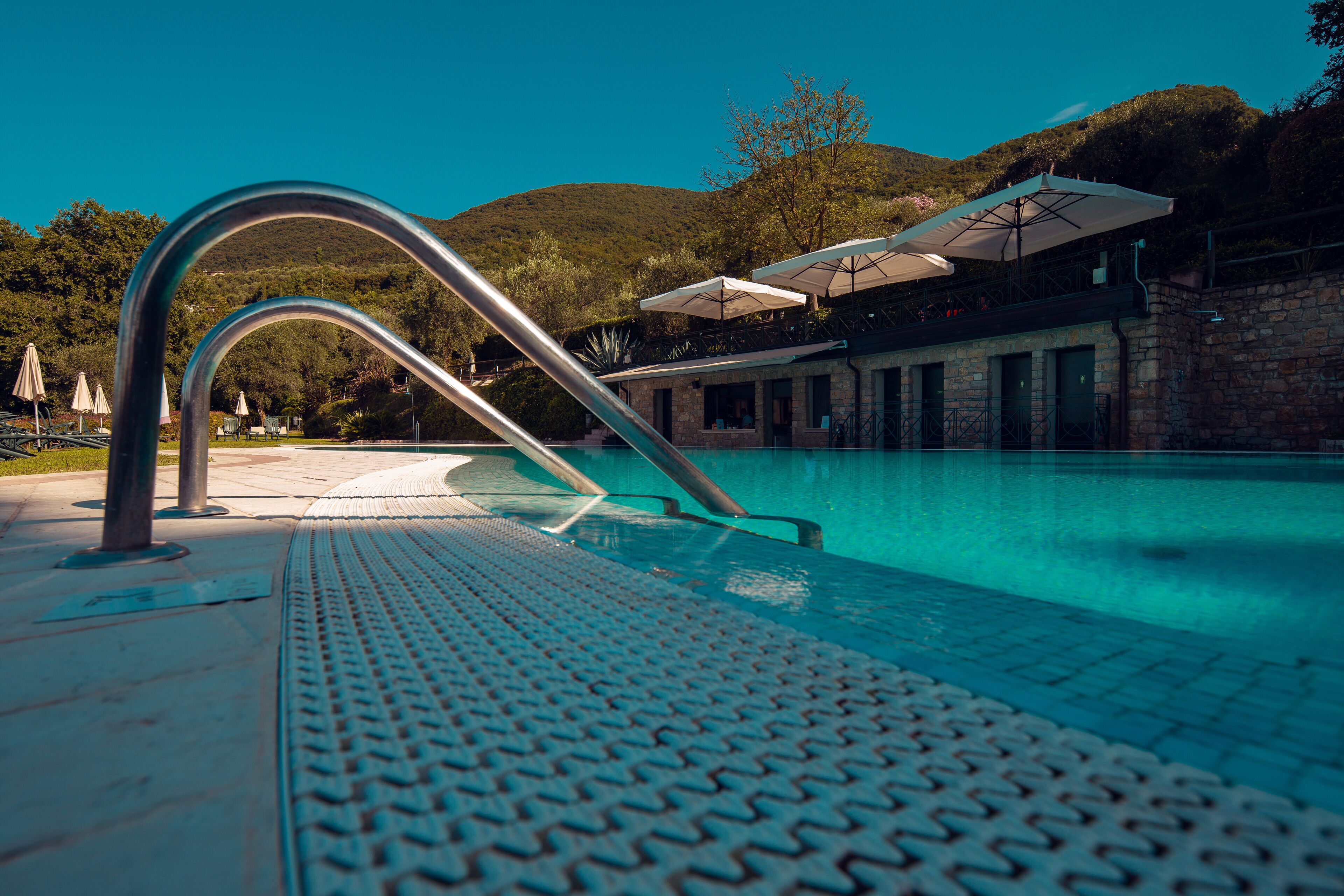 Ein Schwimmbecken mit Metallhandlauf und gefliestem Beckenrand.