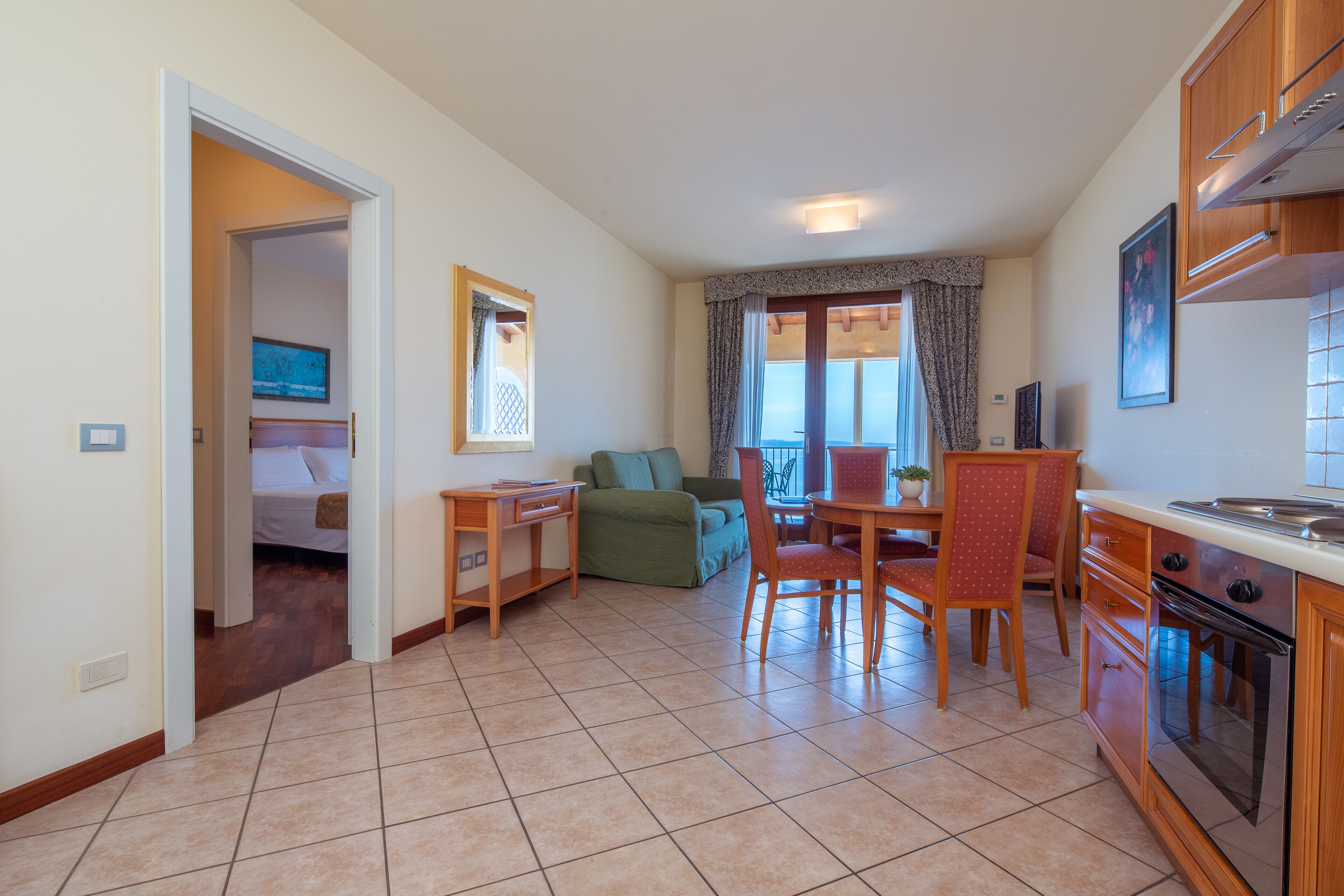 A compact living space with a kitchenette, a dining area, and a bedroom.