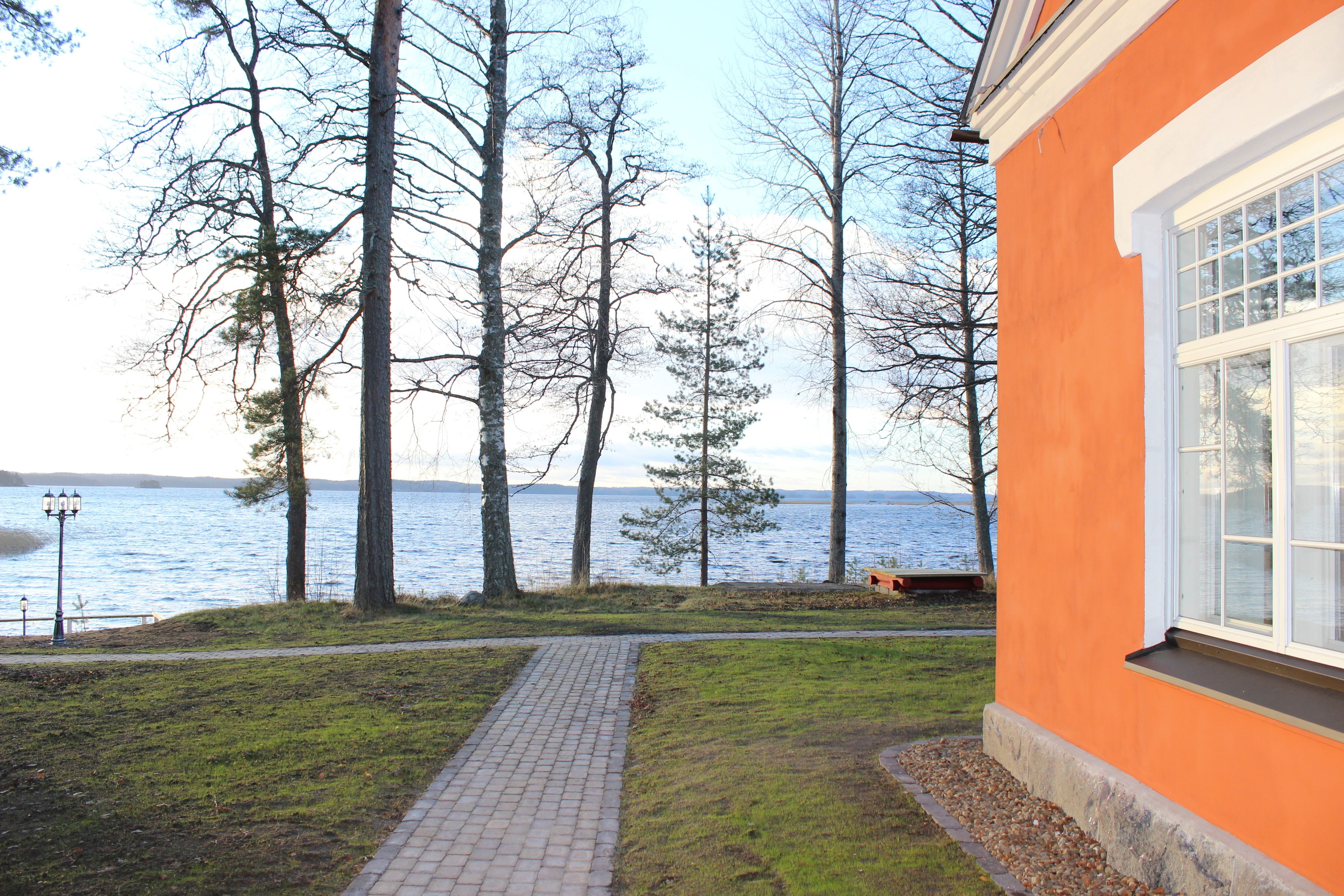 A pathway leading to a building with a view of a lake and trees.