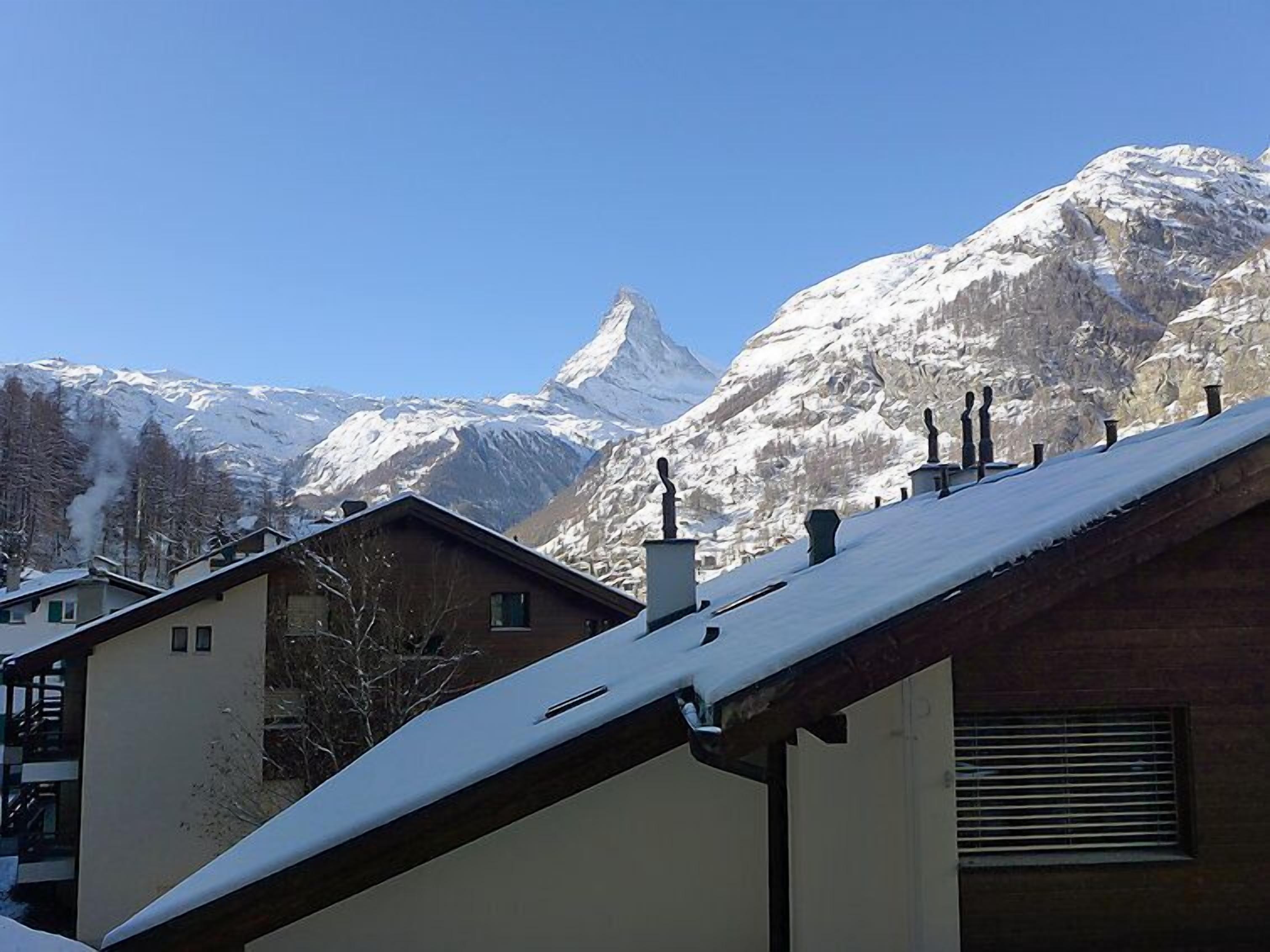 A mountain with snow-covered peaks and a clear sky.