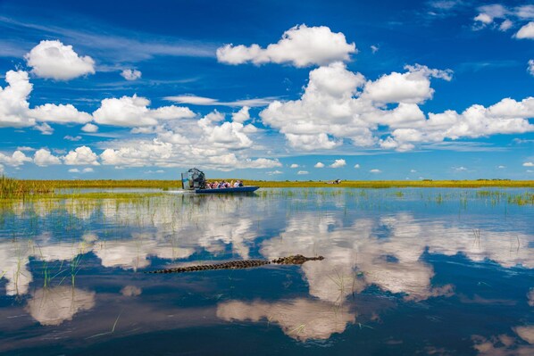 Un bote sobre aguas tranquilas, con cielo despejado y nubes.