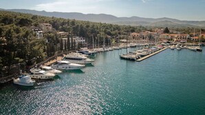 Un port de plaisance où sont amarrés des bateaux, entouré d’arbres et de bâtiments.