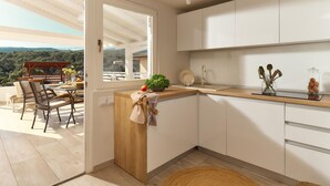 Une cuisine moderne avec des armoires blanches, un plan de travail en bois et une vue sur l’extérieur.