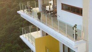 A modern multi-story building with balconies, outdoor seating, and potted plants. - Beautiful Condo in Alamar with fabulous OCEAN VIEW (La Cruz de Huanacaxtle)
