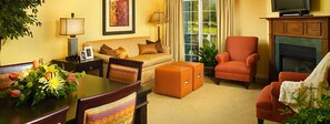 Relax in a cozy living room with a comfortable sofa, armchair, and ottoman, perfect for unwinding and enjoying the view.