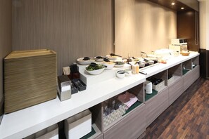 Un buffet proposant une variété de plats et d'ustensiles.
