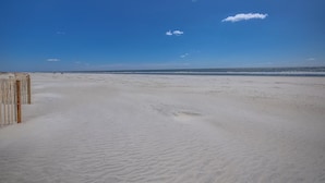 Une plage avec une clôture en bois et un ciel dégagé.
