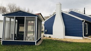 A house with a blue exterior, a white chimney, and a glass-enclosed porch. - 3rd and Surf- 2 blocks from the lake, 1 block from the Legendary Surf Ballroom (Clear Lake)
