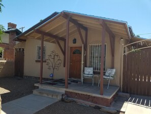 Relax on the covered porch with two comfortable chairs, perfect for unwinding in a secure, well-maintained home.