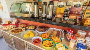 A buffet with various food items and condiments. - Xainã Pousada de Charme (Caucaia)