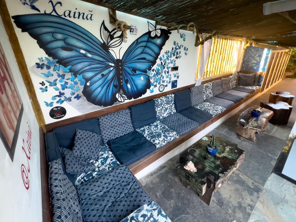 A seating area with patterned cushions and a wall mural of a blue butterfly.