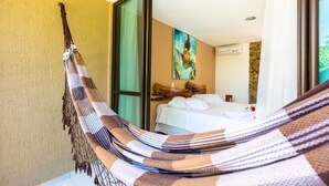 A room with a bed, a hammock, and a painting on the wall. - Xainã Pousada de Charme (Caucaia)