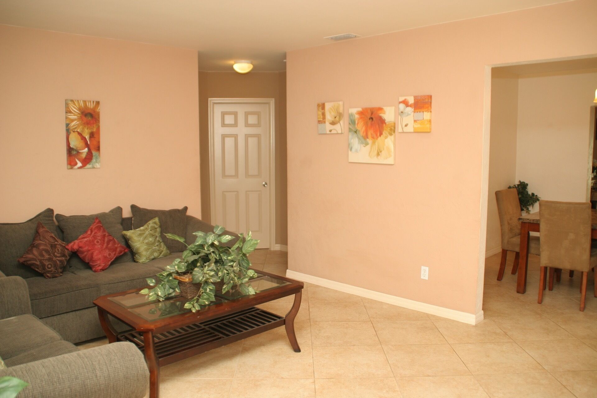 A living room with a sofa, coffee table, and artwork on the walls.