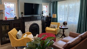 Ein Wohnzimmer mit Kamin, Fernseher und bequemen Sitzgelegenheiten.