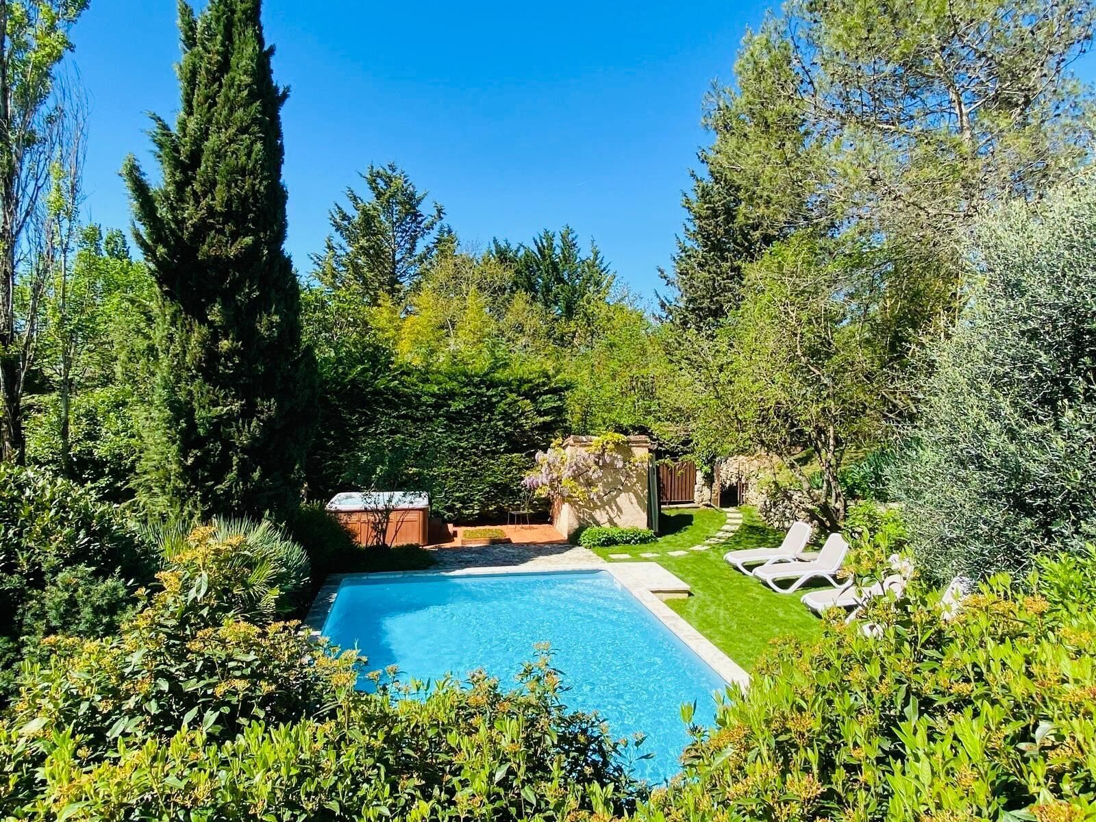 Una piscina al aire libre, sombrillas, tumbonas