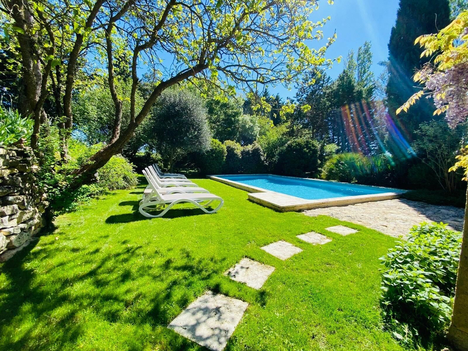 Alberca al aire libre, sombrillas en la alberca y camastros 