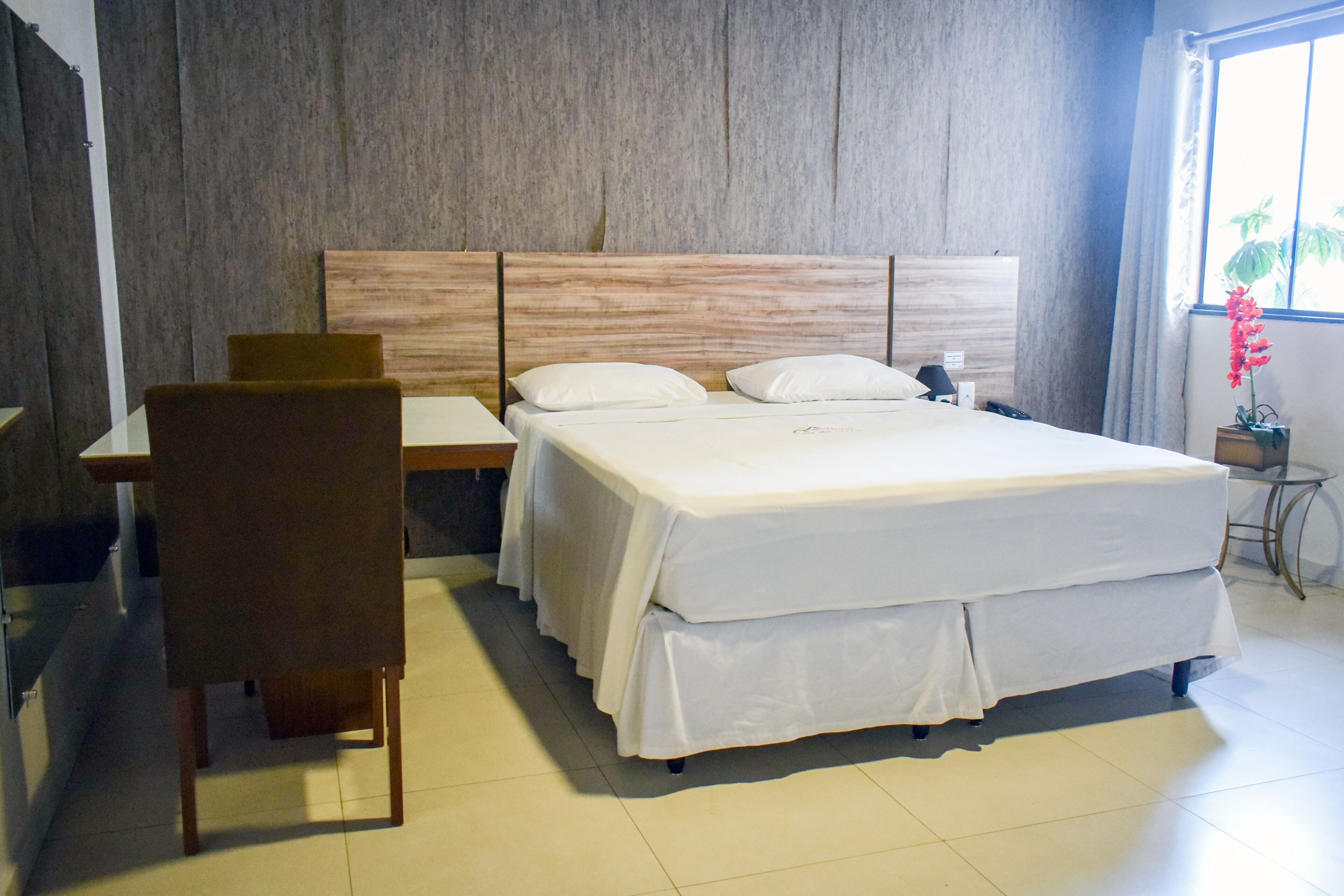 Ein Hotelzimmer mit einem Bett, einem Schreibtisch und einem Stuhl.